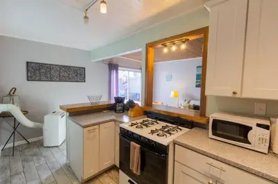 a kitchen with a stove and a microwave at Cozy Ocean Beach Cottage Separate Entry in San Diego