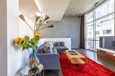 a living room with a blue couch and a red rug at Modern Loft, Quiet, WiFi, Cable, Parking in San Diego