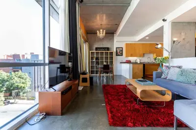 a living room with a blue couch and a red rug at Modern Loft, Quiet, WiFi, Cable, Parking in San Diego