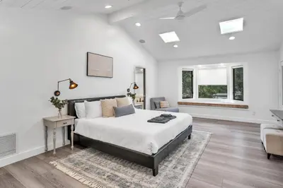 a white bedroom with a large bed and a chair at Upscale 4BR Retreat near Monserate Winery Pool Spa in Fallbrook