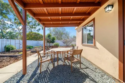 a patio with a table and chairs under a pergola at Decked Out Delight Park Charm in San Diego