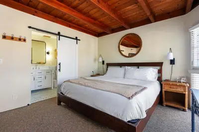 a bedroom with a large bed and a mirror at The Whalen House - Steps from the Ocean in San Diego