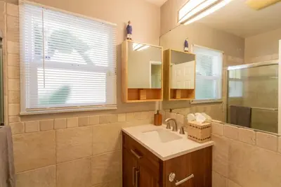 a bathroom with a sink and a mirror at Centrally Located Cottage Near Lake Trails Shops in La Mesa