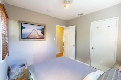 a bedroom with a bed and a picture on the wall at Centrally Located Cottage Near Lake Trails Shops in La Mesa