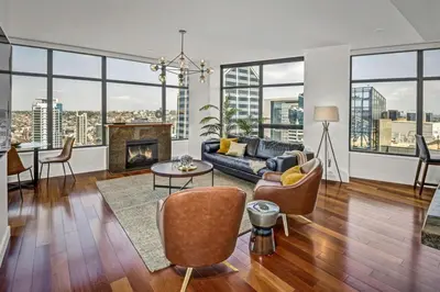 a living room with a couch and a fireplace at Panoramic Bay and City Views - 2BR, Pool, Gym, Parking in San Diego