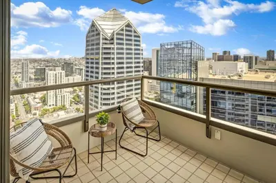 a balcony with chairs and a view of a city at Panoramic Bay and City Views - 2BR, Pool, Gym, Parking in San Diego