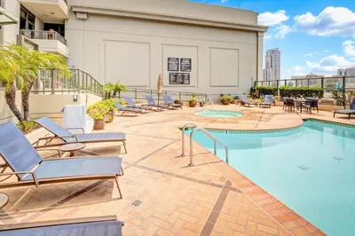 a pool at a hotel with lounge chairs and tables at Panoramic Bay and City Views - 2BR, Pool, Gym, Parking in San Diego