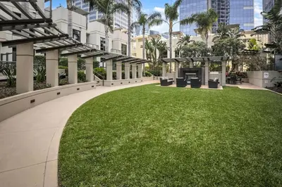 a large grassy area with chairs and buildings at Panoramic Bay and City Views - 2BR, Pool, Gym, Parking in San Diego