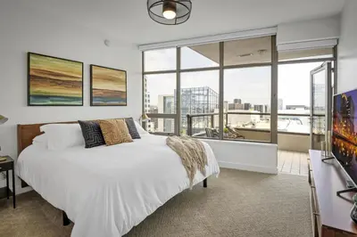 a bedroom with a large white bed and large windows at Panoramic Bay and City Views - 2BR, Pool, Gym, Parking in San Diego