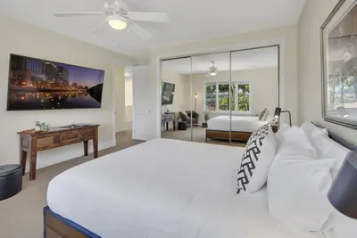 a white bedroom with a large bed and a desk at Hilltop Del Mar Lux Infinity Pool Panoramic Views in San Diego