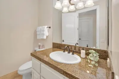a bathroom with a sink and a toilet and a mirror at Hilltop Del Mar Lux Infinity Pool Panoramic Views in San Diego