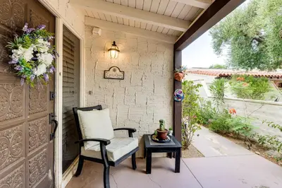 a porch with a chair and a table and a door at 2 Mi to Galleta Meadows Desert Golf Retreat! in Borrego Springs