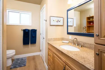 a bathroom with a sink and a toilet and a mirror at Steps from the Sand Mission Beach House in San Diego