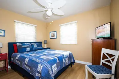 a bedroom with a bed and a ceiling fan at Steps from the Sand Mission Beach House in San Diego
