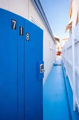 a row of blue doors on the side of a building at Steps from the Sand Mission Beach House in San Diego