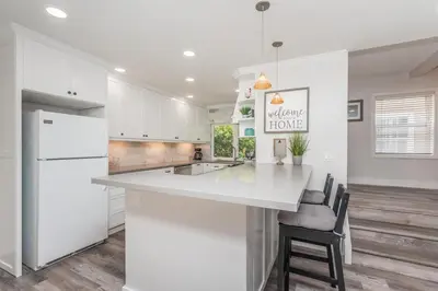 a kitchen with white cabinets and a white counter top at Seaside Retreat in San Diego