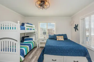 a bedroom with two bunk beds and a chandelier at Seaside Retreat in San Diego