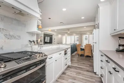 a kitchen with white cabinets and a stove top oven at Seaside Retreat in San Diego