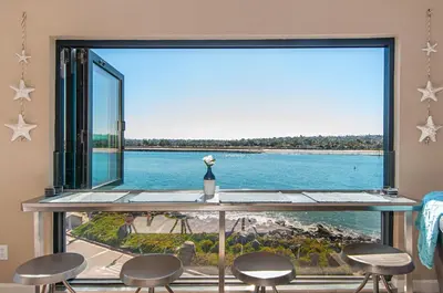 a room with a large window with a view of the water at Ocean Vista Penthouse 1 in San Diego