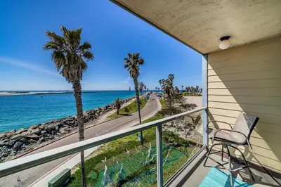 a balcony with a chair and a view of the ocean at Ocean Vista Penthouse 1 in San Diego