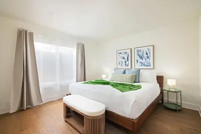 a bedroom with a bed with a green blanket on it at La Jolla Hillside Views and Coastal Comfort in San Diego