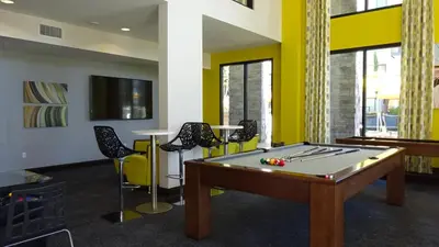 a room with a pool table and chairs at Ariva in San Diego