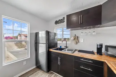 a kitchen with a stainless steel refrigerator and a sink at Charming Gem in LH, High Speed WiFi Minutes from Beach, Downtown & Petco Park! in San Diego