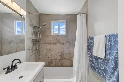 a bathroom with a tub and a shower with a sink at Charming Gem in LH, High Speed WiFi Minutes from Beach, Downtown & Petco Park! in San Diego
