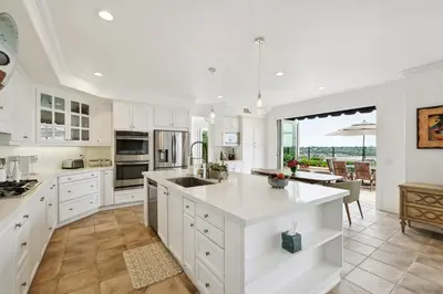 a kitchen with white cabinets and a large island at Exquisite Panoramic View Estate in Newport Beach
