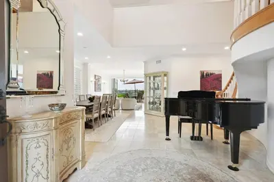 a living room with a piano and a dining room at Exquisite Panoramic View Estate in Newport Beach