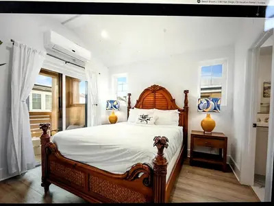 a bedroom with a large bed with a wooden headboard at Beach Bloom in San Diego