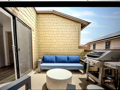 a patio with a blue couch on a balcony at Beach Bloom in San Diego