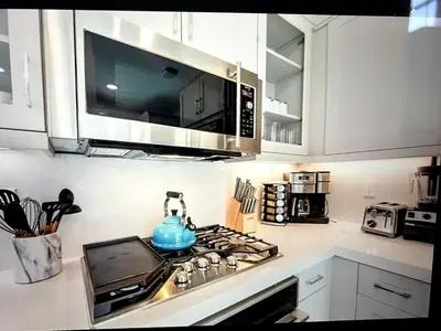 a kitchen with a stove with a tea kettle on it at Beach Bloom in San Diego