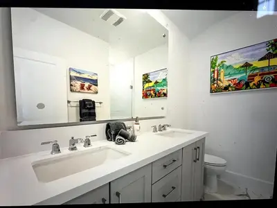 a white bathroom with a sink and a mirror at Beach Bloom in San Diego