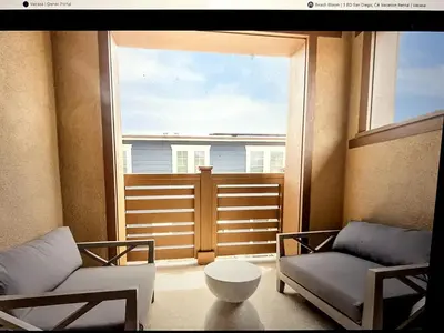 a living room with two chairs and a large window at Beach Bloom in San Diego