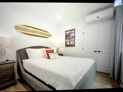 a bedroom with a large white bed with a light above it at Beach Bloom in San Diego
