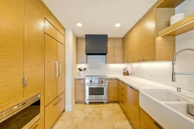 a kitchen with wooden cabinets and a sink and a stove at Aqua Luxe - SUR113 in Solana Beach