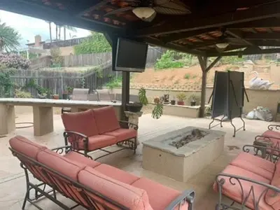 a patio with chairs and a fireplace and a tv at Room in Bay Park, San Diego in San Diego