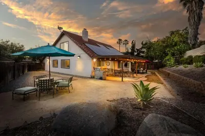 a house with a patio with a table and an umbrella at 5 Bedroom Home With Firepit in San Diego