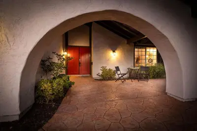 an archway leading to a patio with a red door at 5 Bedroom Home With Firepit in San Diego