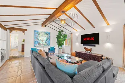 a living room with a couch and a tv at Spacious Spanish Hacienda Close to Everything in San Diego
