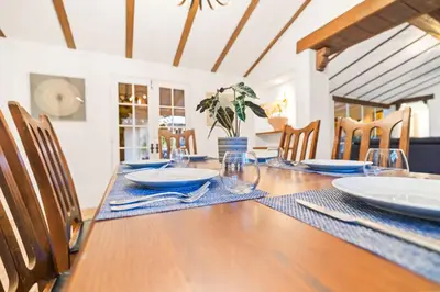 a dining room table with plates and glasses on it at Spacious Spanish Hacienda Close to Everything in San Diego