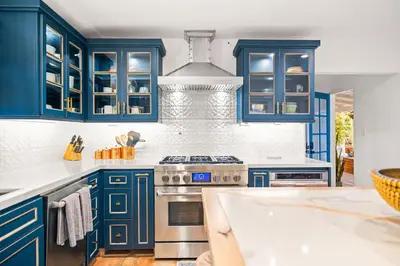 a kitchen with blue cabinets and a stove at Spacious Spanish Hacienda Close to Everything in San Diego
