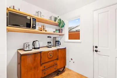 a kitchen with a wooden dresser with a microwave on top at Spacious Spanish Hacienda Close to Everything in San Diego