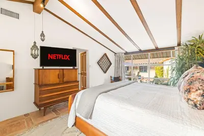 a bedroom with a bed and a tv on a wall at Spacious Spanish Hacienda Close to Everything in San Diego