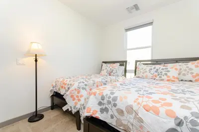 a bedroom with a bed and a lamp and a window at Modern 2BR Near Petco Park & Convention Center in San Diego