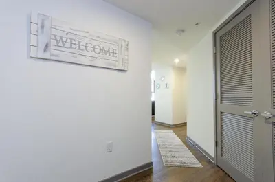 a hallway with a white wall with a picture on the wall at Modern 2BR Near Petco Park & Convention Center in San Diego