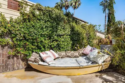 a couch sitting in front of a bush at Boho Oasis with Pool Spa Firepit BBQ Ping Pong in San Diego