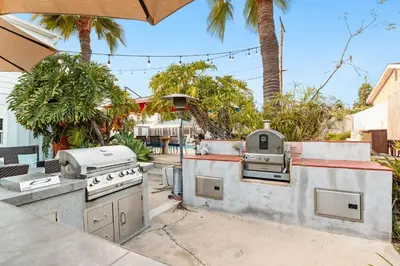 a outdoor kitchen with a grill and a grill at Boho Oasis with Pool Spa Firepit BBQ Ping Pong in San Diego