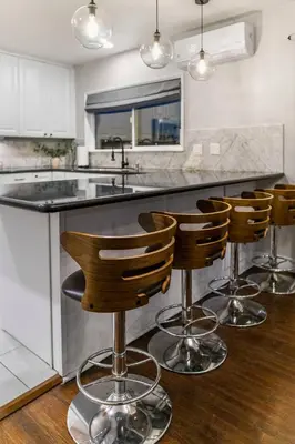 a kitchen with a bar with four bar stools at Spacious House close to Petco Park and Gaslamp in San Diego